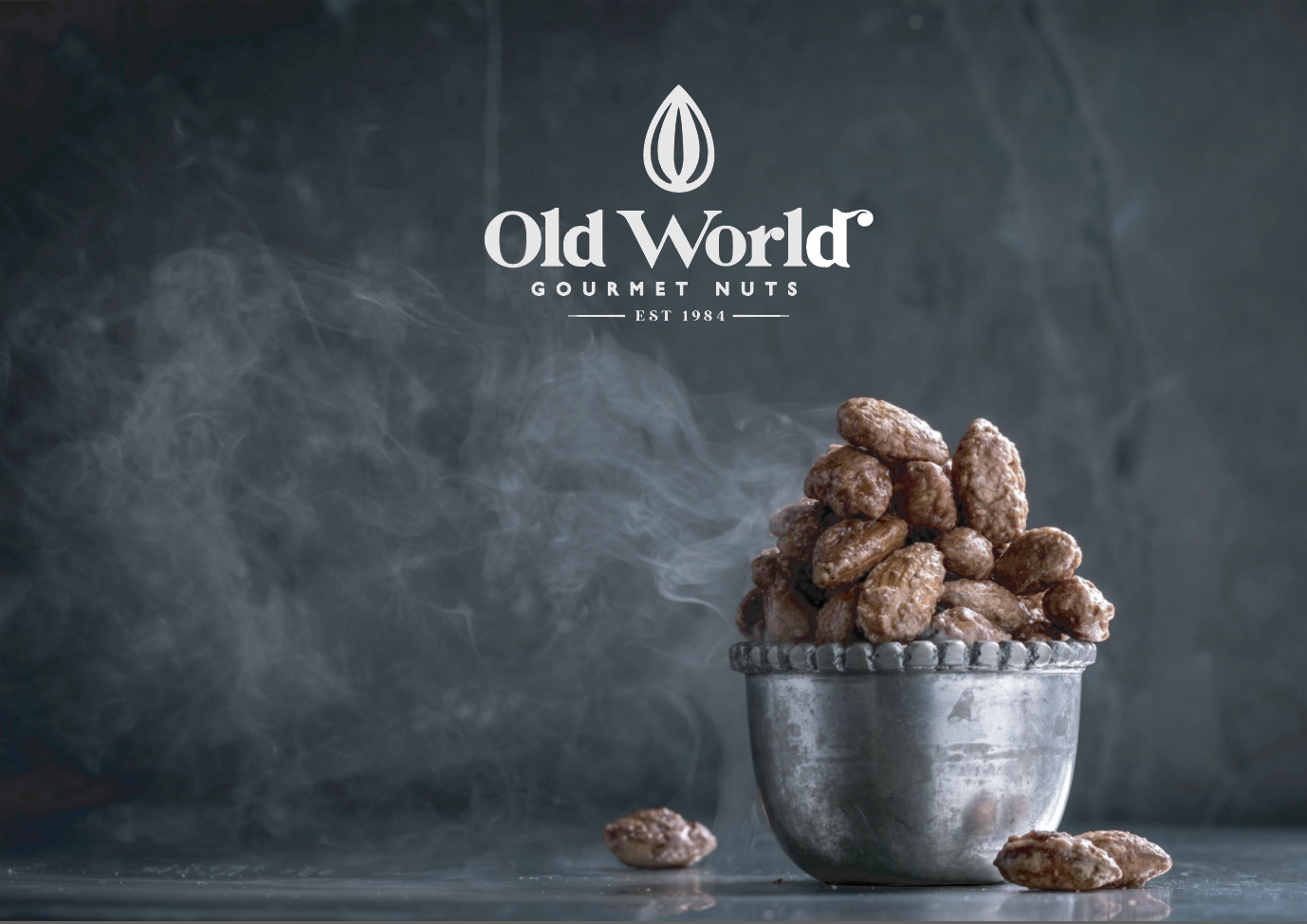Bowl of Old World Gourmet Nuts with brand logo on a dark background
